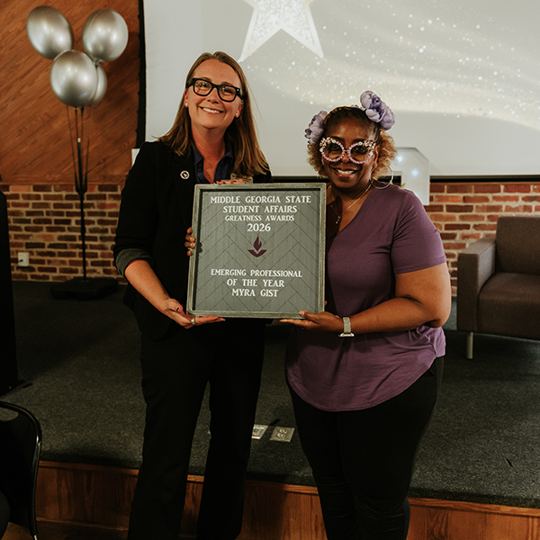 Dr. Jennifer Brannon and award recipient Myra Gist smile while holding a plaque that reads, "Middle Georgia State Student Affairs Greatness Awards 2026 - Emerging Professional of the Year, Myra Gist."